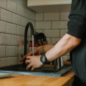 person getting water from a faucet