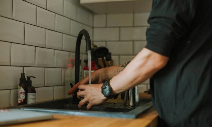 person getting water from a faucet